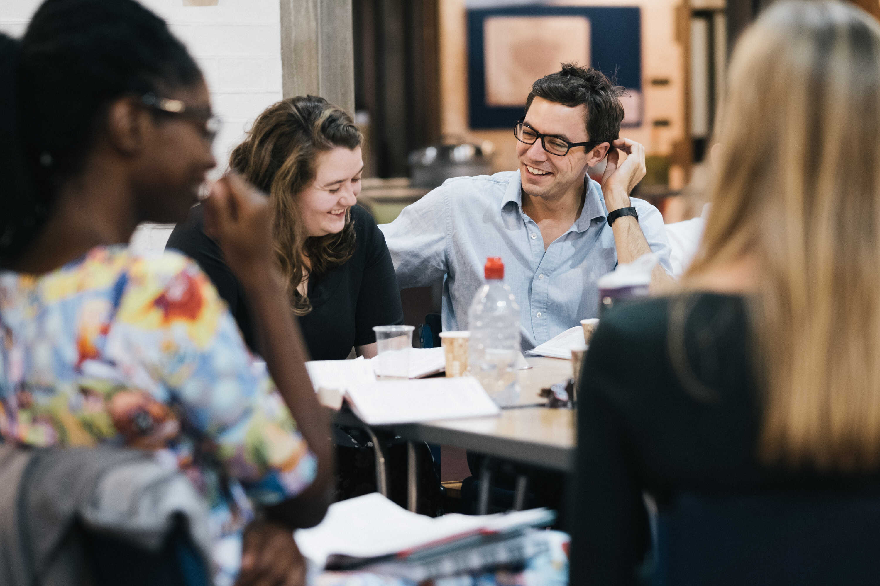 People smiling around a table at a Bible study