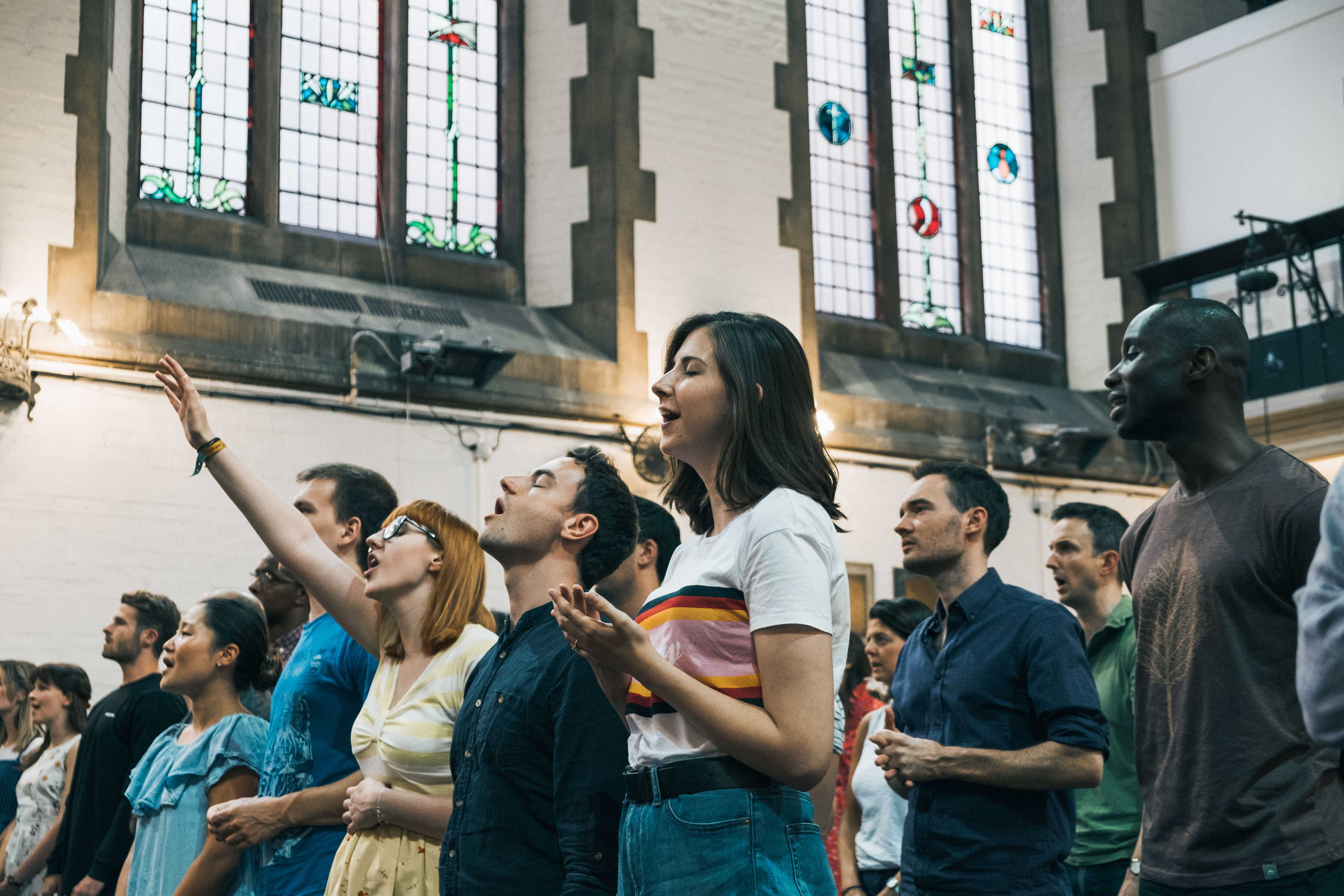 People praising God with their hands raised and eyes closed